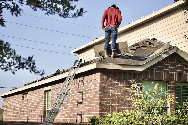 Professional roofer working on a residential roof in Village Shires